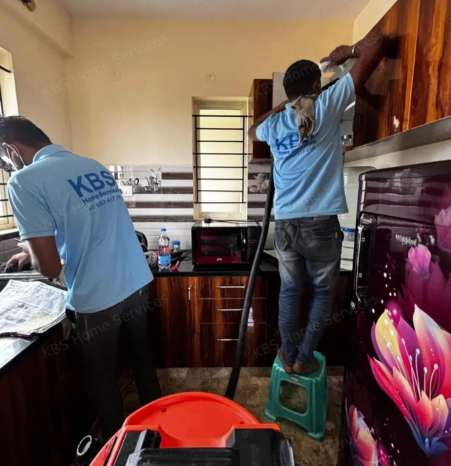 KBS team deep cleaning kitchen cabinets and shelves in a Bengaluru apartment
